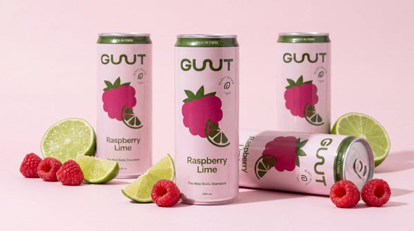 A premium display of GUUT Raspberry Fresh Lime functional fibre soda cans surrounded by natural ingredients.